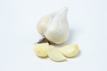 Peeled garlic next to whole garlic on a white background. Healthy vegetable
