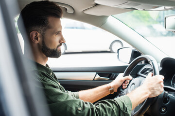 Side view of brunette man driving car