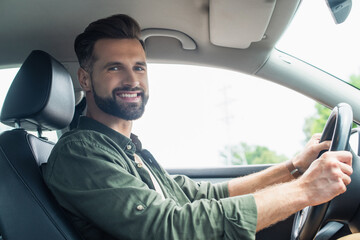 Bearded driver smiling at camera in auto