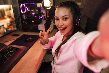 Smiling young woman gamer in headphones © Drobot Dean