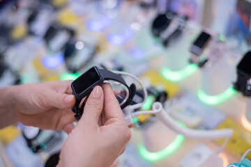 Faceless caucasian woman chooses a smart watch in an electronics store