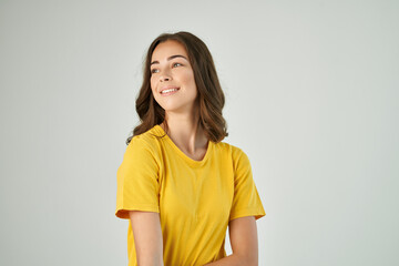 Obraz premium cheerful brunette in yellow t-shirts Studio light background