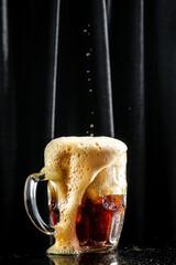 Beer. dark cold beer. pouring beer into glass, with thick foam