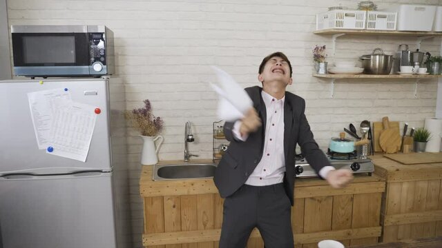slow motion emotional male entrepreneur holding paper notification is spreading arm while screaming and celebrating for business success with excitement at home