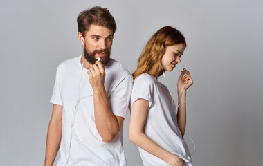 man and woman in white t-shirts are standing next to friendship music in headphones