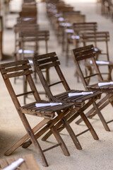 File di sedie in legno con ventaglio bianco sulla seduta allineate per la cerimonia di nozze civili