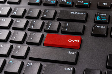 OMG red key on a black pc keyboard. Desktop keyboard with Omg gamer slang button. Keypad enter...