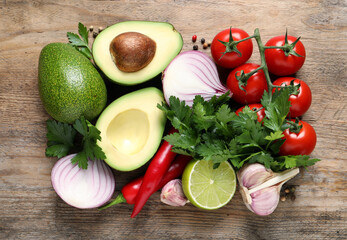 Fototapeta na wymiar Fresh ingredients for guacamole on wooden table, flat lay
