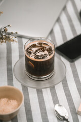 a glass of morning americano on the table with other accessories