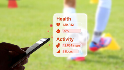 
Tracking of health data and fitness using a fitness tracker or a smartphone, with football training in the background, e-health, digitalization in the healthcare sector