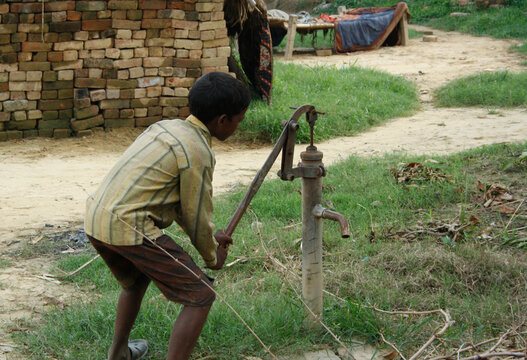 Indian poor boy pouring water. India is a developing nation. Although its economy is growing, poverty is still a major challenge. It has around 84 million people living in extreme poverty.
