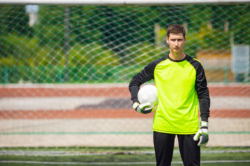 Portrait man goalkeeper with soccer ball in stadium sport