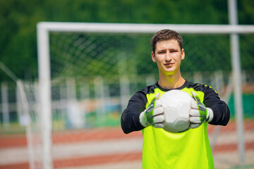 Goalkeeper with soccer ball in stadium sunlight, banner sport