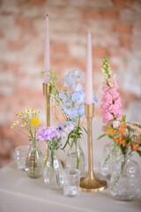 Particolare delle decorazioni floreali nei vasetti trasparenti e candele sul tavolo imperiale allestito per un a cerimonia