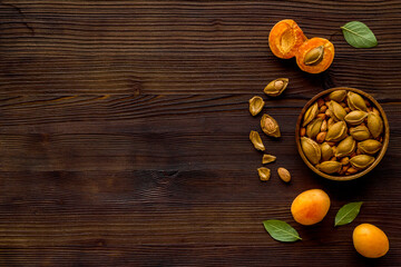 Apricots and apricot pits kernel in bowl. Overhead view