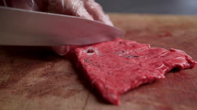 Chef Neatly Chopping Meat. The chef cuts the meat, beef close-up.