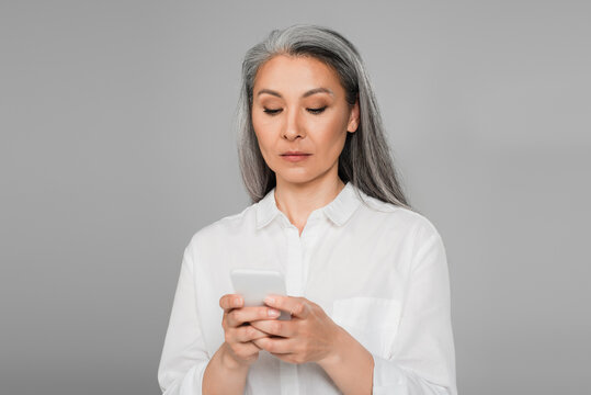 Serious Mature Woman Messaging On Mobile Phone Isolated On Grey