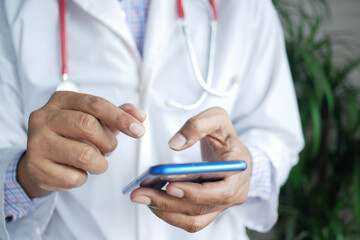 doctor in white coat using a smartphone.