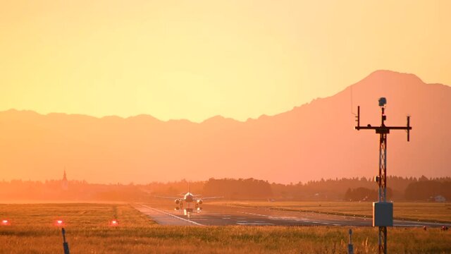 Passenger airplane taxiing on Ljubljana airport runway. Amazing and colorful sunset colors. Plane spotting in Slovenia. Aircraft preparing for takeoff. Real time, static shot
