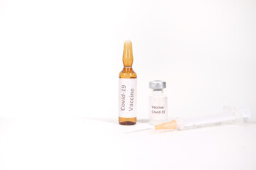 Close up of coronavirus vaccine and syringe on white background