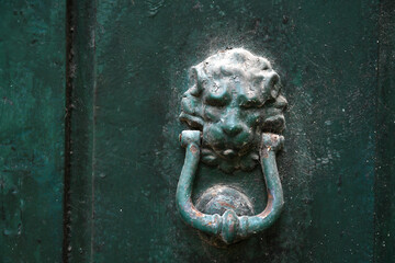 old door knocker on green wooden door