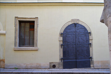 Facade of an old building with vintage gate and window. Frontal view. Kutna Hora, Central Bohemian Region, Czech Republic.