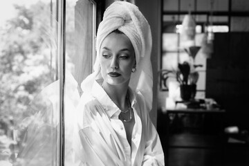 Portrait of beautiful woman wearing white shirt and turban town on head while daydreaming at the...