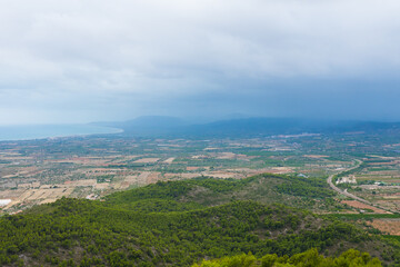 Spanish plains and hills from the Santa Llucia belvedere (Alcossebre-Alcala de Xivert, Spain). Beautiful view of magnificent nature. Cloudy day on the panoramic spot.