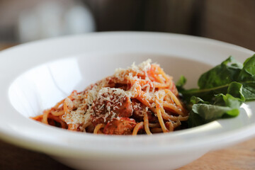 spaghetti Bolognese with italian sausage and tomato sauce with parmesan cheese and basil