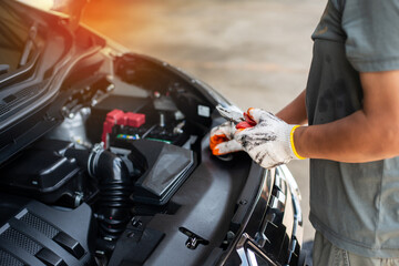White gloved man's hand holding working pliers to inspect engine