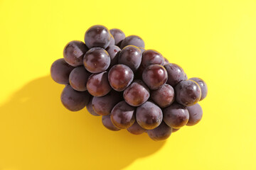 Red grapes isolated in yellow background