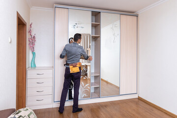 Closet Cabinets Contractor. Finishing Wooden Wardrobe by Professional Installer.