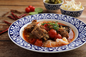 Local northern thai food Rice noodles with pork in spicy soup in wood background