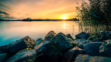 View of a dutch river from the waterfront during sunrise
