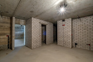 Empty basement room with minimal preparatory repairs. interior with white brick walls