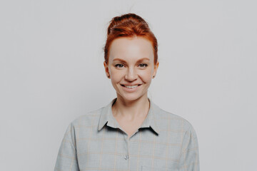 Headshot portrait of happy young caucasian ginger woman being satisfied and feeling happy