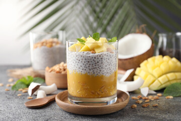 Obraz na płótnie Canvas Delicious chia pudding with mango, mint and granola on grey table