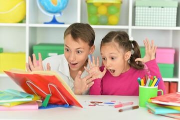 Fototapeta premium Porait of surprised brother and sister doing homework together