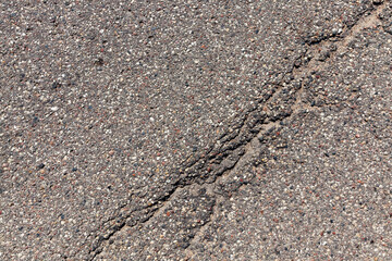 an asphalt road with a lot of holes and damage