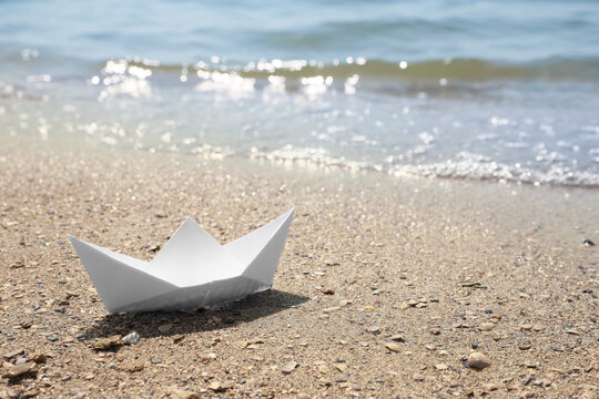 White paper boat near sea on sunny day, space for text
