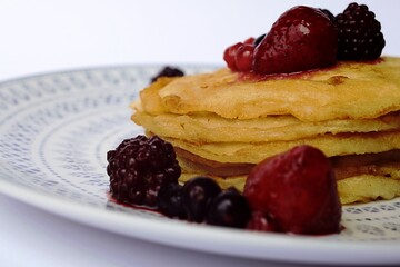 pancakes with red berries on white background
