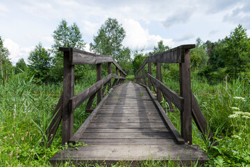 Fototapeta na wymiar old wooden bridge built on the lake