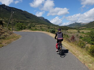 Obraz premium jeune femme à vélo qui randonne en itinérant à bicyclette dans le sud de la France