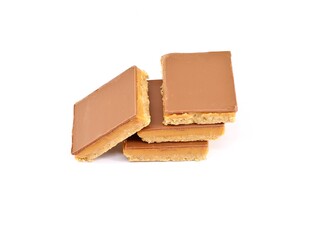 Caramel shortcakes, or shortbread, on white background. They are biscuits made of shortbread topped with caramel and chocolate.