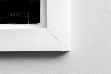 White window cornice cracked in the corner caused by the inexperience of the builders in the...