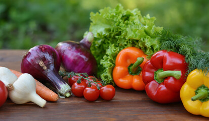 A set vegetables on a wooden background: carrots, potatoes, zucchini, paprika, cucumber, garlic, tomatoes, lettuce.Healthy food concept with vegetables and ingredients for cooking. Top view.Copy space