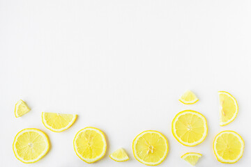 Fruit background with lemon slices top view. Sliced yellow fruit on a white wooden table. Copy space.