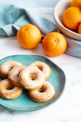 Home made baked whole wheat vegan donuts with orange glaze