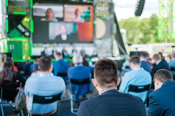 Participants of open air conference listening to speaker