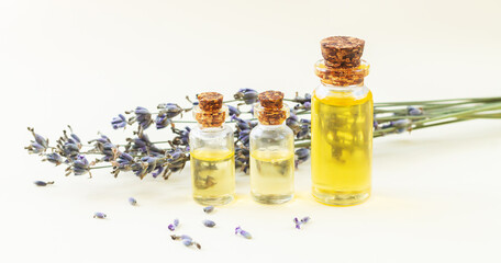 Glass bottles of lavender essential oil or natural perfume with dried lavender flowers
